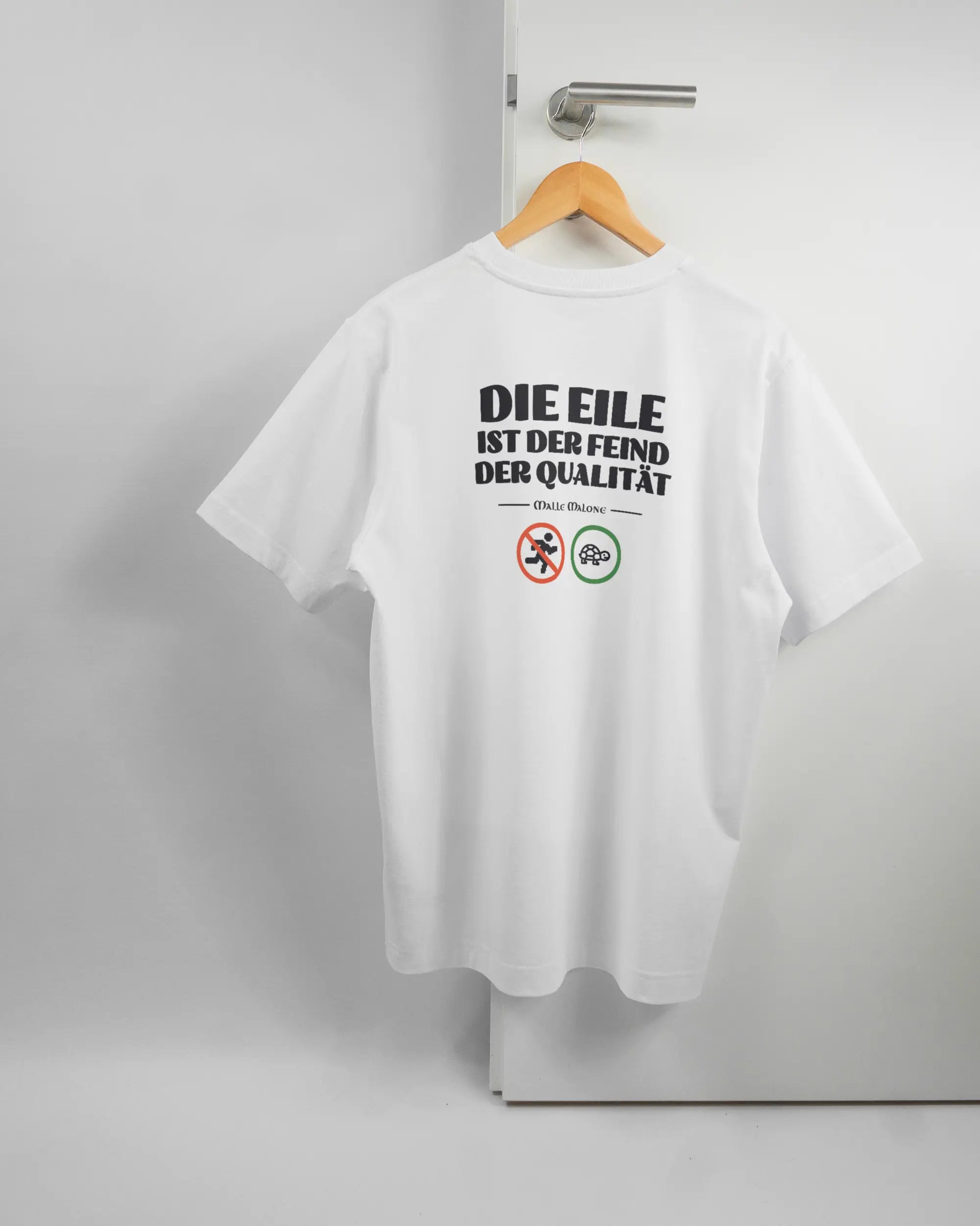 Rückseite des Organic Unisex T-Shirt Heavy Oversized von Maondo mit dem Design Keine Eile in der Farbe White und in der Größe S auf einem Bügel an der Türklinke aufgehängt