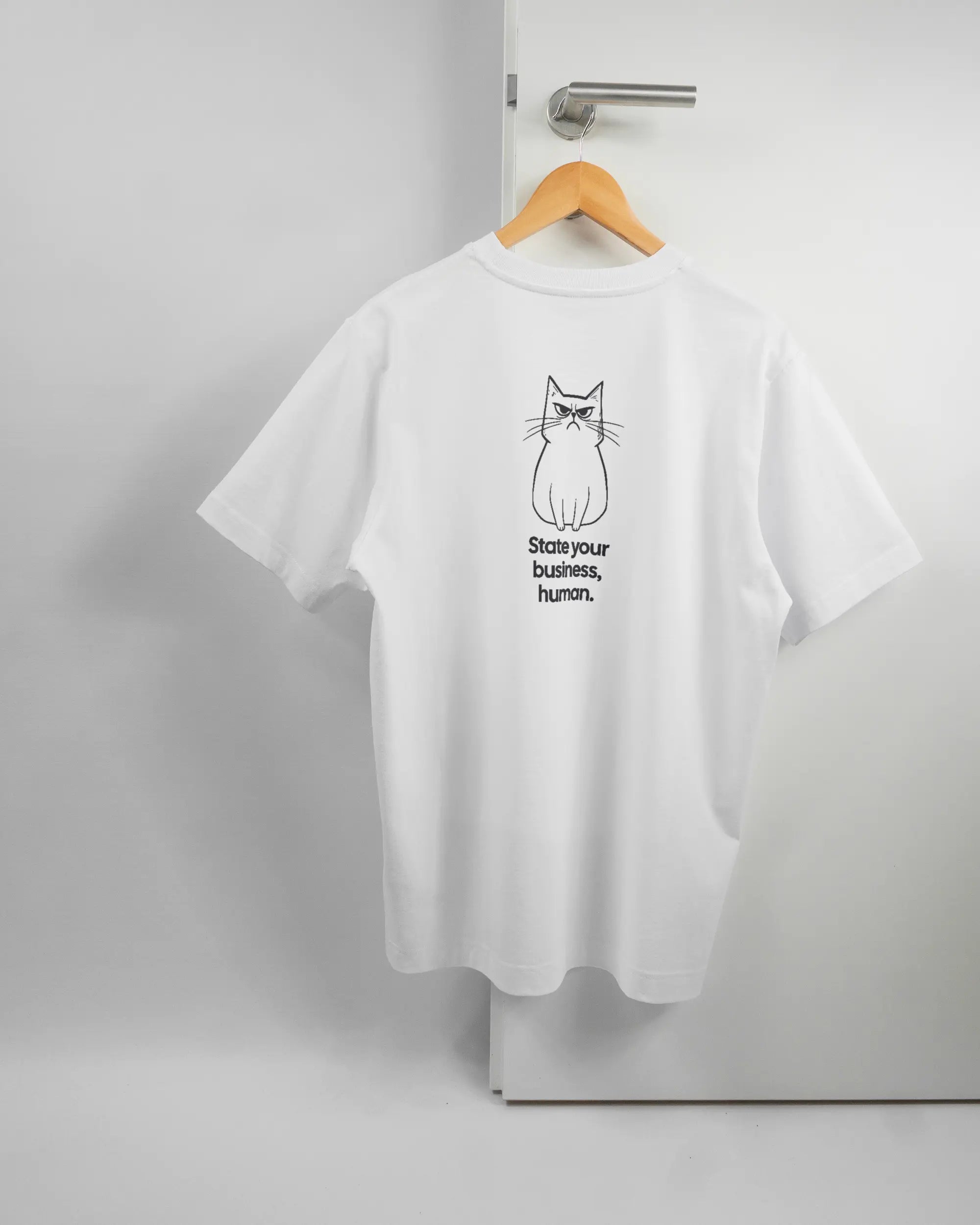 Rückseite des Organic Unisex T-Shirt Heavy Oversized von Maondo mit dem Design Grumpy Purr in der Farbe White und in der Größe S auf einem Bügel an der Türklinke aufgehängt