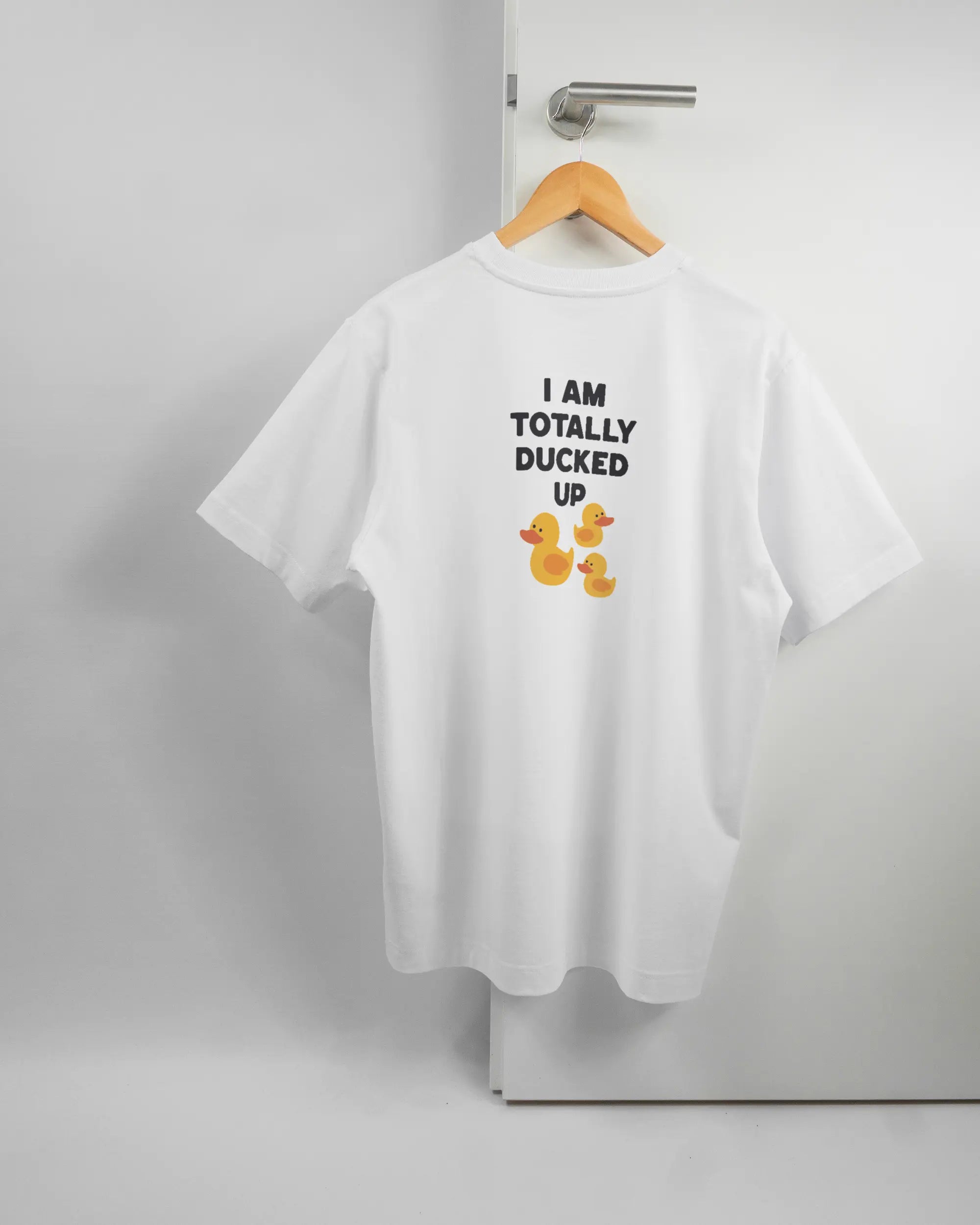 Rückseite des Organic Unisex T-Shirt Heavy Oversized von Maondo mit dem Design Ducked Up in der Farbe White und in der Größe S auf einem Bügel an der Türklinke aufgehängt