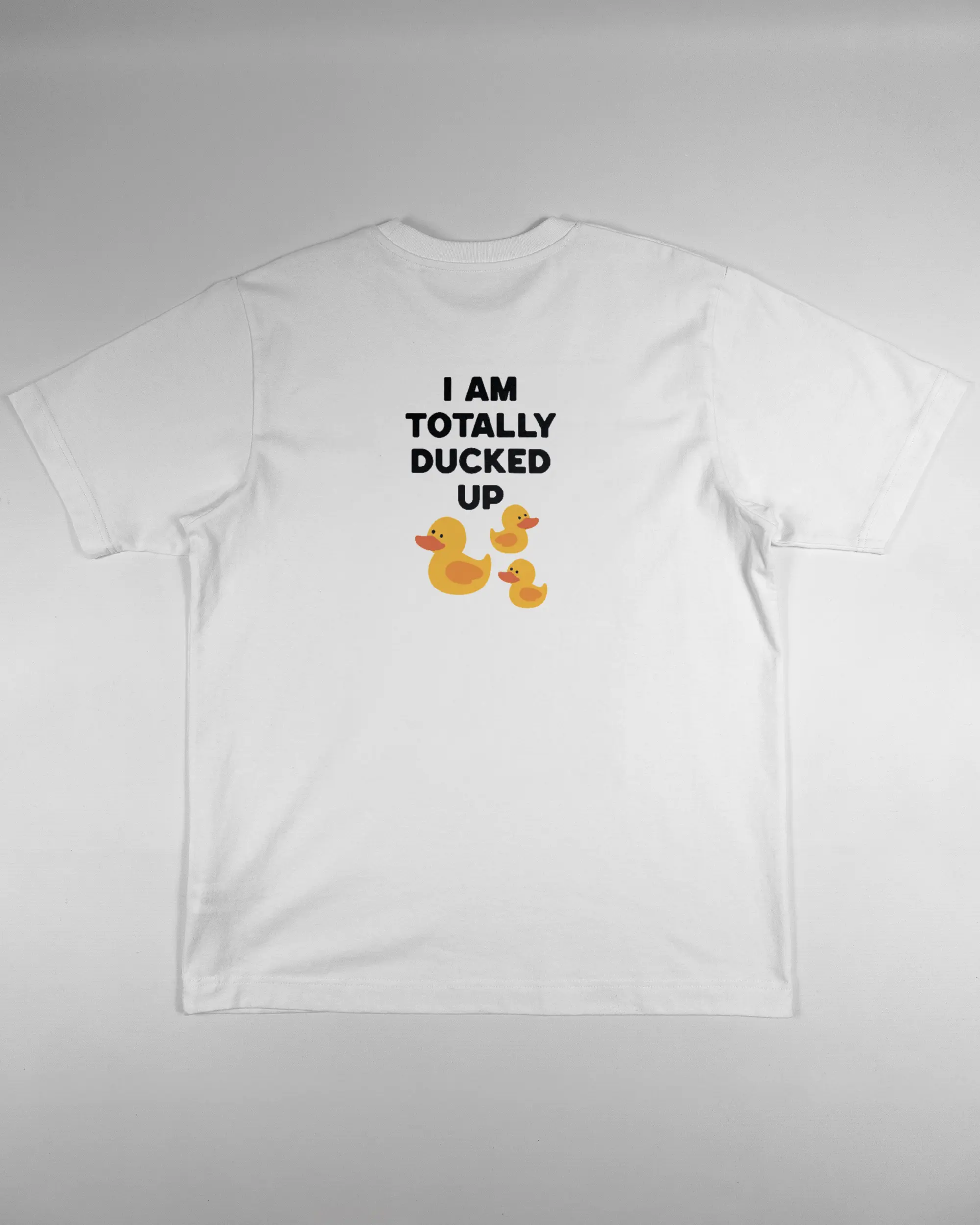 Rückseite des Organic Unisex T-Shirt Heavy Oversized von Maondo mit dem Design Ducked Up in der Farbe White und in der Größe S flach auf den Boden gelegt